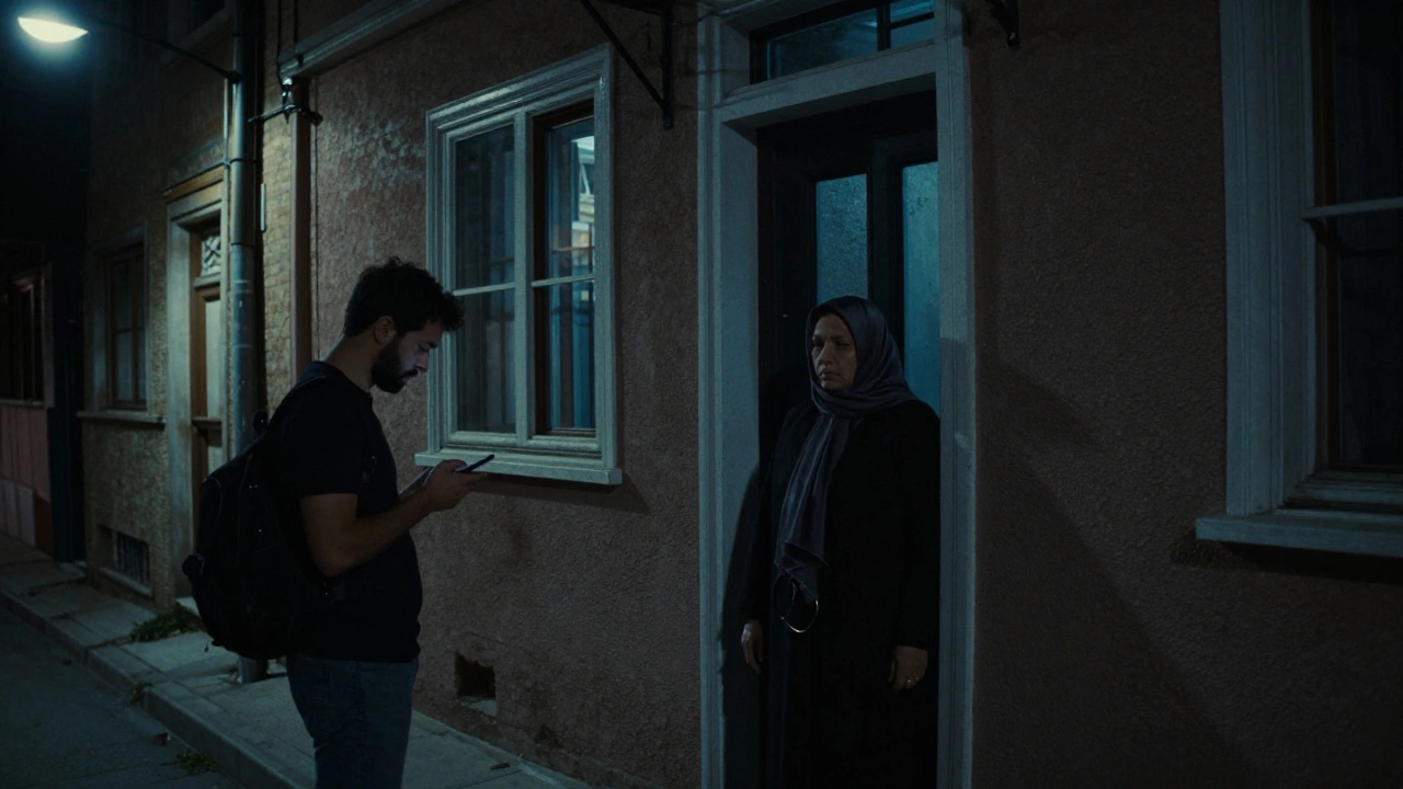 A tourist texts near a quiet apartment building at night, waiting for a discreet massage appointment in Istanbul.
