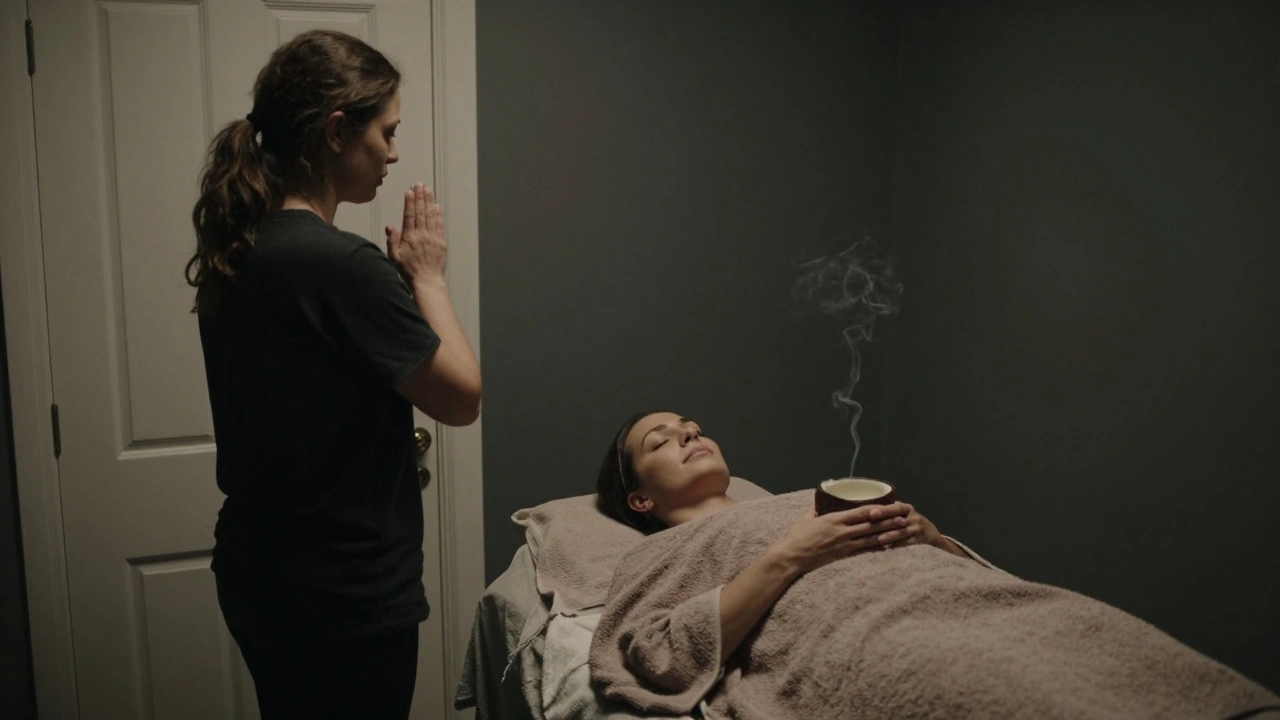 A healing practitioner pauses outside a private room, where a woman rests wrapped in a towel, oil nearby.