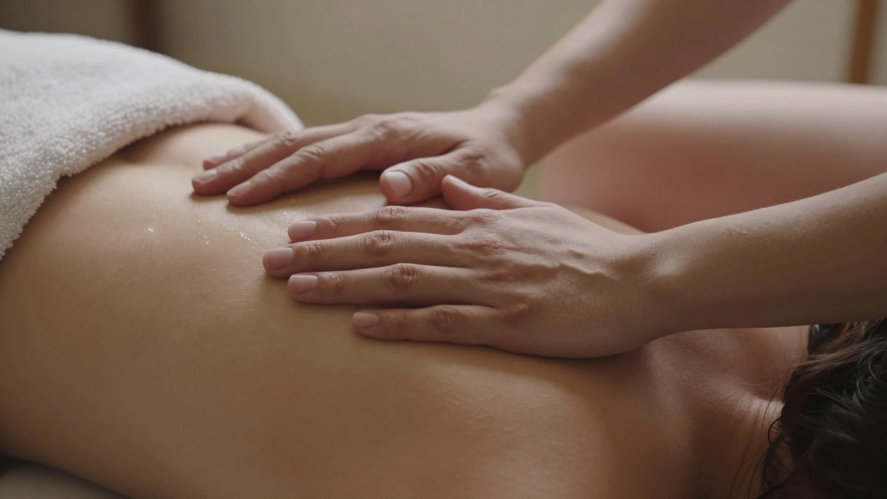 Close-up of hands resting on a draped shoulder, with a therapist's forearm and thigh softly overlapping the client in a calming, non-invasive embrace.